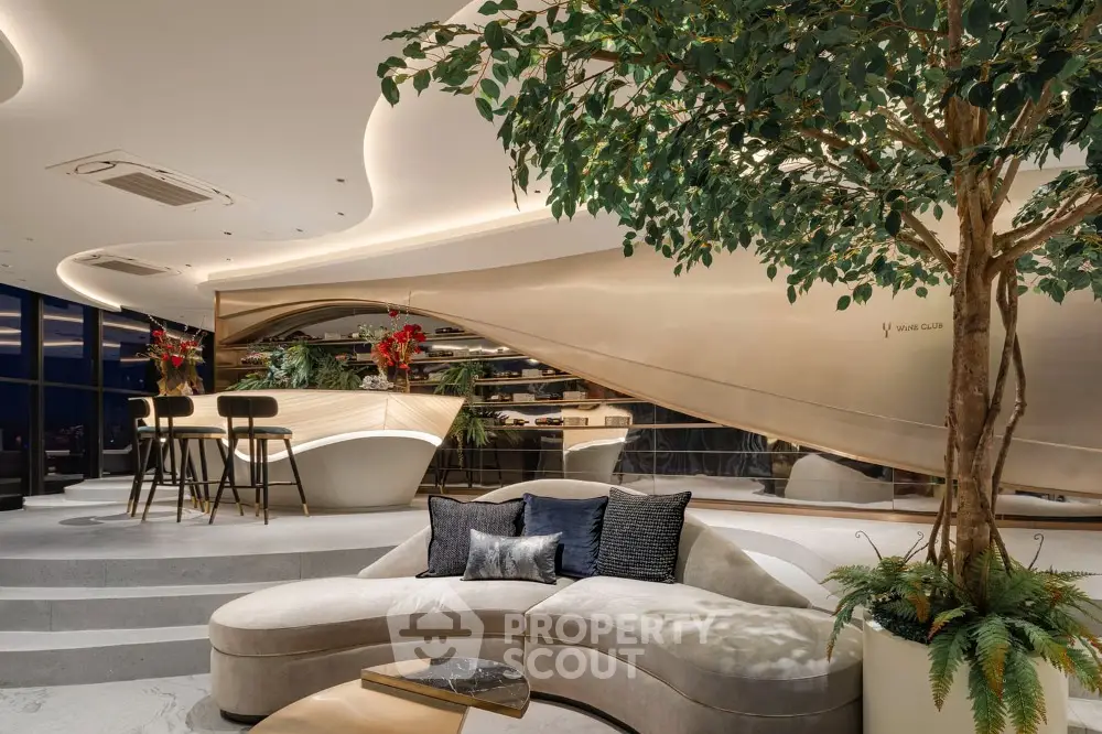 Luxurious open-plan living space with modern curved sofa, elegant lighting, and indoor greenery, perfect for upscale urban living.