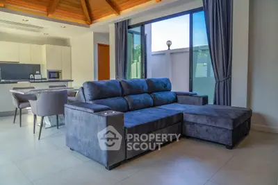 Modern living room with stylish furniture and open kitchen layout, featuring a cozy sectional sofa and elegant dining area.