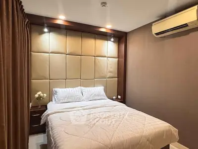 Cozy bedroom with elegant padded headboard and modern lighting