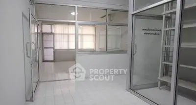Spacious office space with glass partitions and ample natural light.