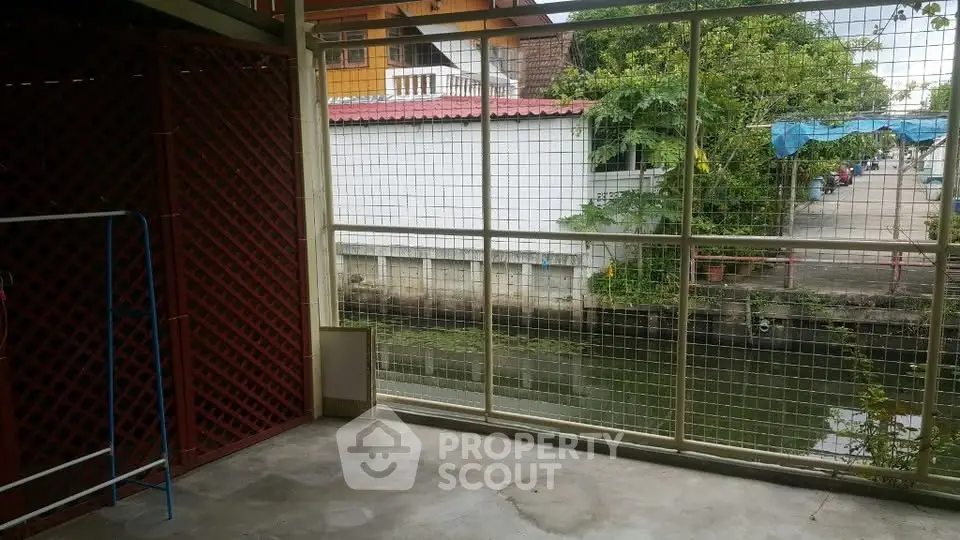 Charming canal-side view from a secure balcony in a residential area.