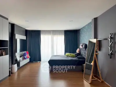 Spacious modern bedroom with stylish decor and large window for natural light.