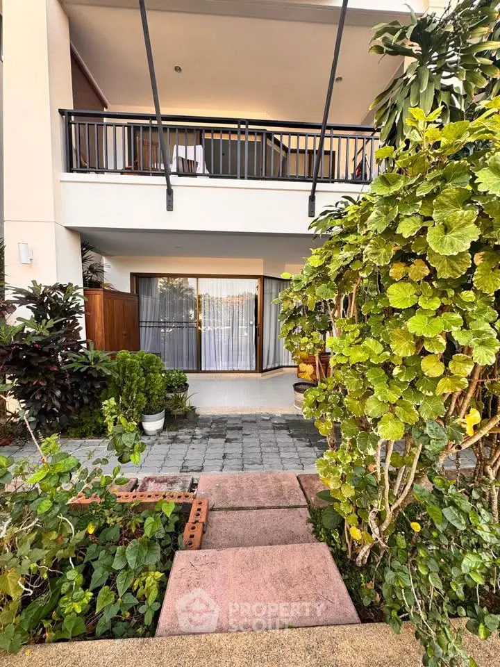 Charming two-story home with lush garden and spacious balcony, perfect for outdoor relaxation.