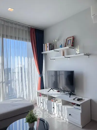 Modern living room with large window and stylish decor in a high-rise apartment.