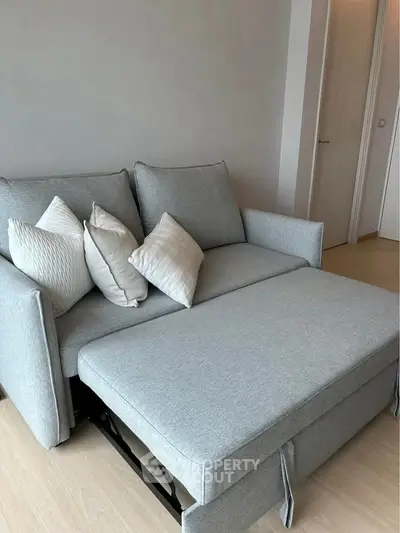Modern living room with stylish gray sofa bed and cozy pillows