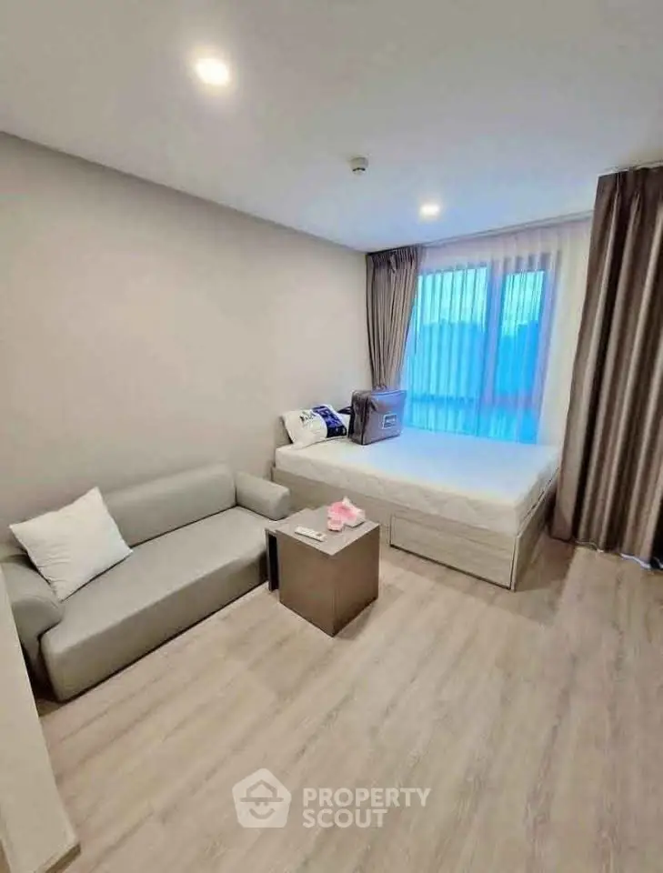 Modern studio apartment with cozy bed and stylish sofa, perfect for urban living.