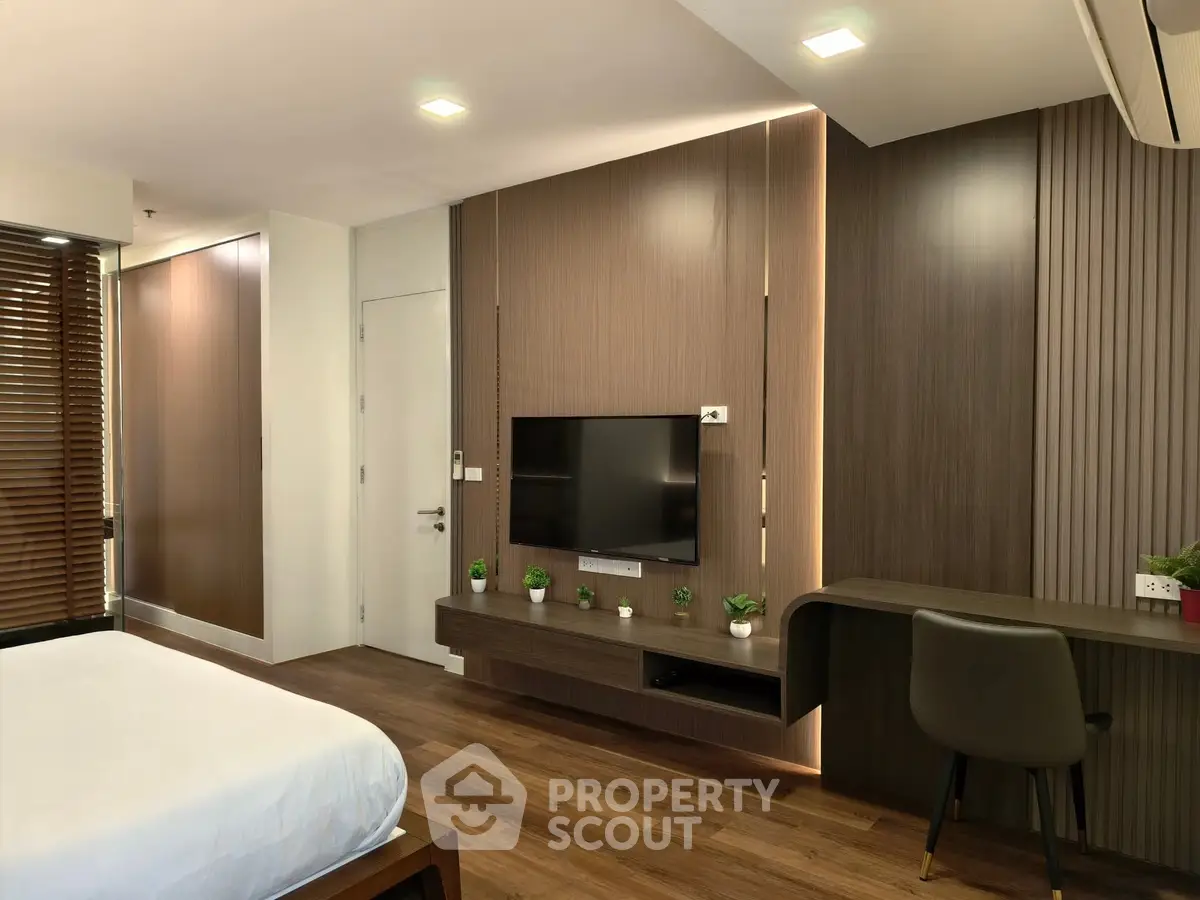 Modern bedroom with sleek wooden paneling and built-in TV unit