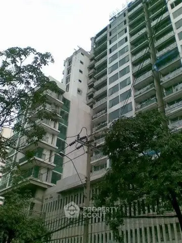 Modern high-rise building with glass windows and lush greenery