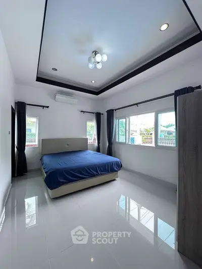 Spacious bedroom with large windows and modern decor