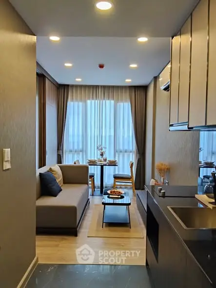 Modern living room with open kitchen, cozy seating, and elegant dining area.