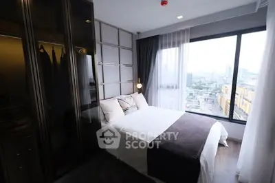 Modern bedroom with large window offering city view, featuring sleek design and cozy ambiance.