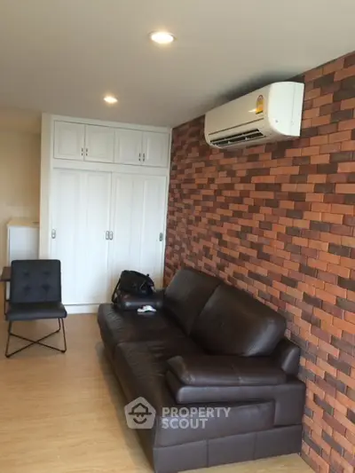 Modern living room with brick accent wall and leather sofa