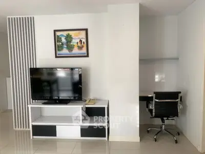 Modern living room with TV and study area, sleek design and bright ambiance.