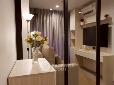 Modern living room with elegant decor and air conditioning, featuring a cozy sofa and stylish lighting.
