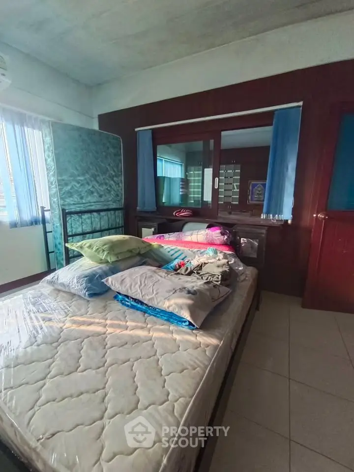 Cozy bedroom with natural light and simple furnishings, ideal for a comfortable living space.