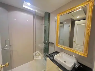 Elegant bathroom with modern shower and stylish gold-framed mirror