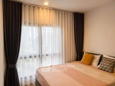 Cozy bedroom with elegant curtains and stylish bedding in modern apartment