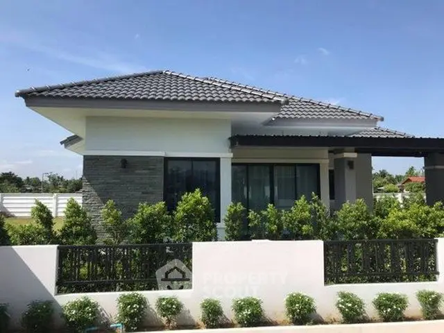 Modern single-story house with landscaped garden and stylish roof design.