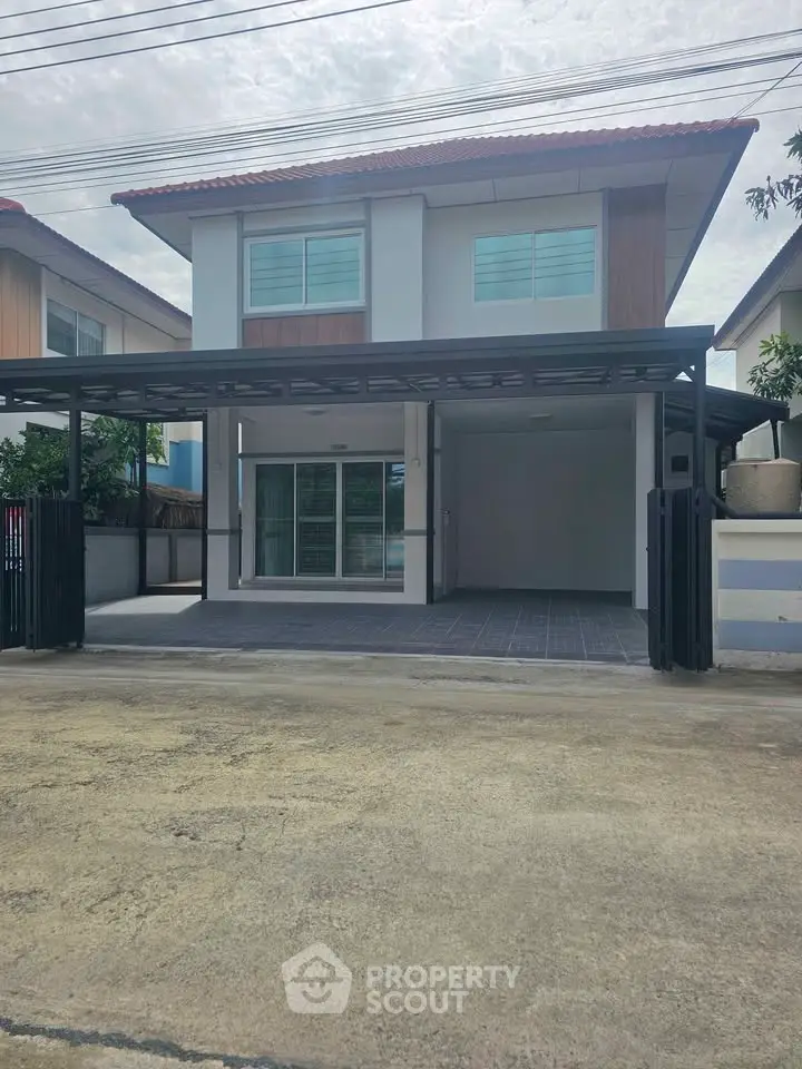 Modern two-story house with spacious driveway and sleek design in a suburban neighborhood.