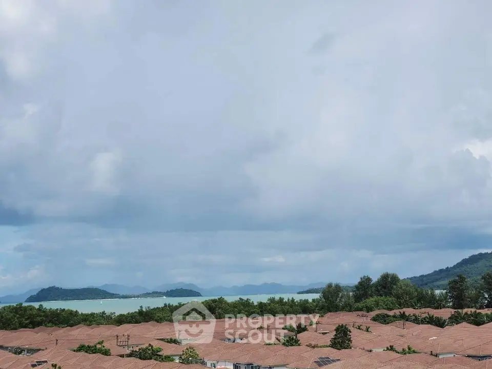 Scenic view of coastal residential area with ocean and mountains in the background.