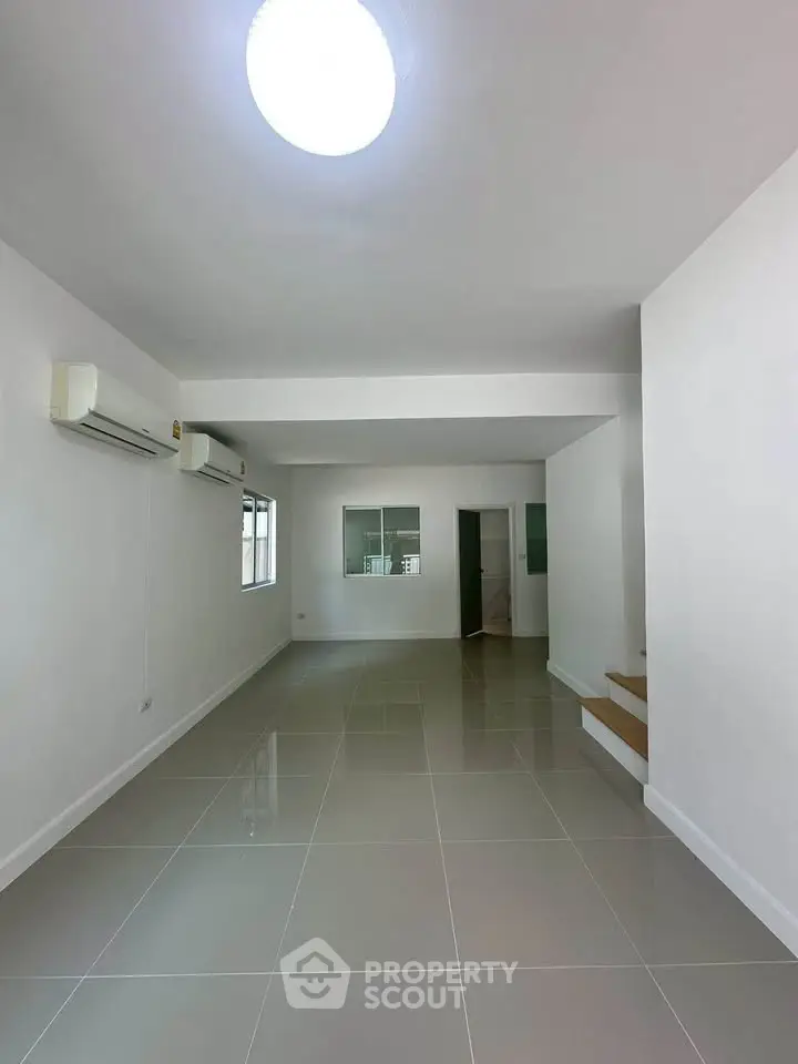 Spacious modern living room with sleek tile flooring and air conditioning, perfect for comfortable living.