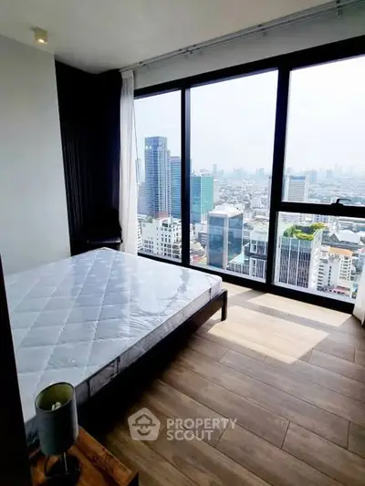 Stunning bedroom with floor-to-ceiling windows offering breathtaking city views in a modern high-rise apartment.