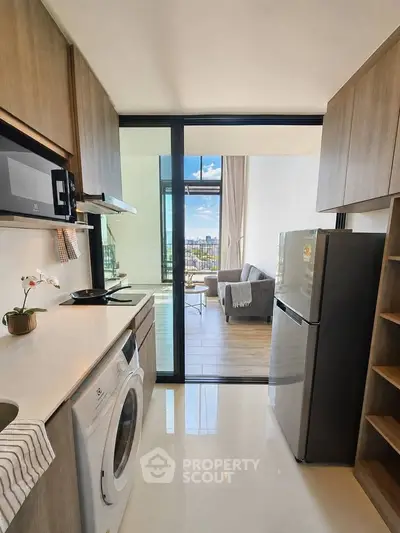 Modern kitchen with sleek appliances and open view to stylish living room