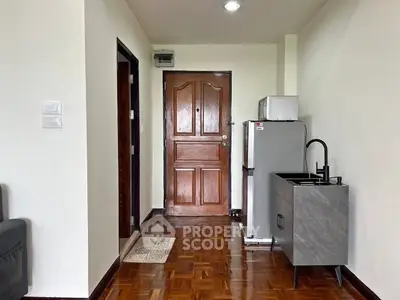 Cozy apartment entrance with compact kitchenette and wooden flooring
