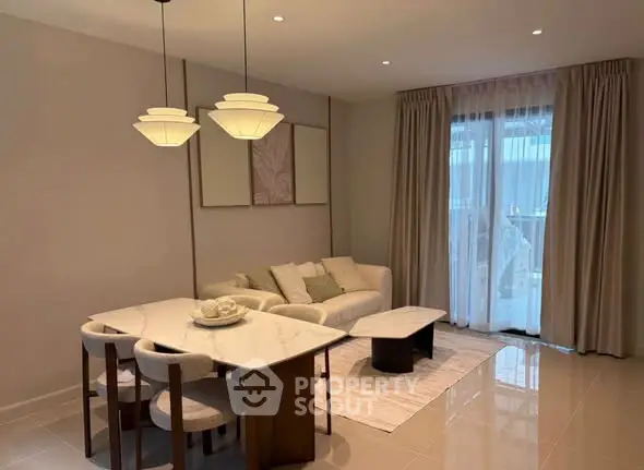 Elegant living room with modern decor, featuring a cozy sofa, stylish dining area, and large window with curtains.