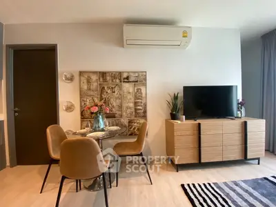 Modern living room with stylish decor, featuring a dining area and entertainment center.