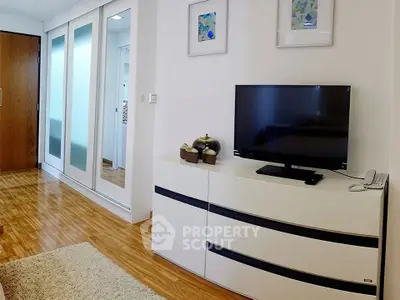 Modern living room with sleek TV stand and mirrored closet doors