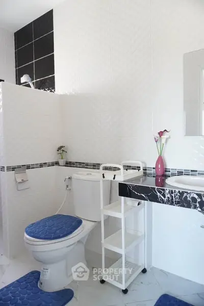 Modern bathroom with sleek white tiles and stylish black accents