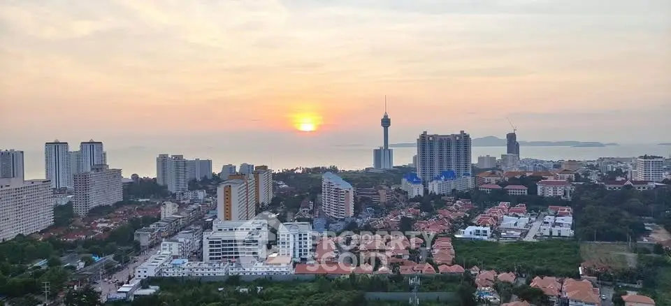 Stunning cityscape view with sunset over ocean, showcasing urban skyline and coastal beauty.