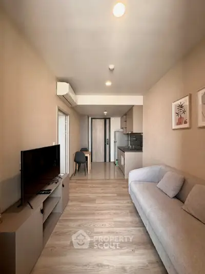 Modern living room with sleek furniture and open kitchen layout in a stylish apartment.