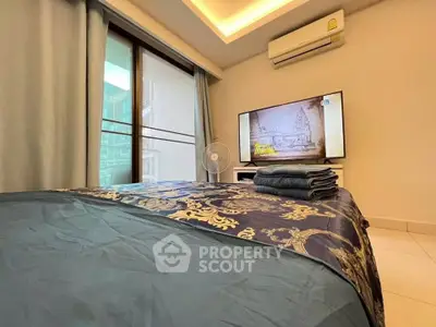 Luxurious bedroom with elegant bedding, air conditioning, and a large TV for ultimate comfort.