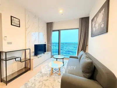 Modern living room with stylish decor and stunning city view from large window.