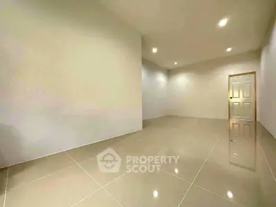 Spacious empty room with glossy tiled floor and recessed lighting, ideal for customization.