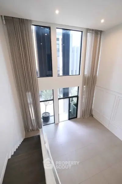 Spacious modern living room with high ceilings and large windows offering abundant natural light.