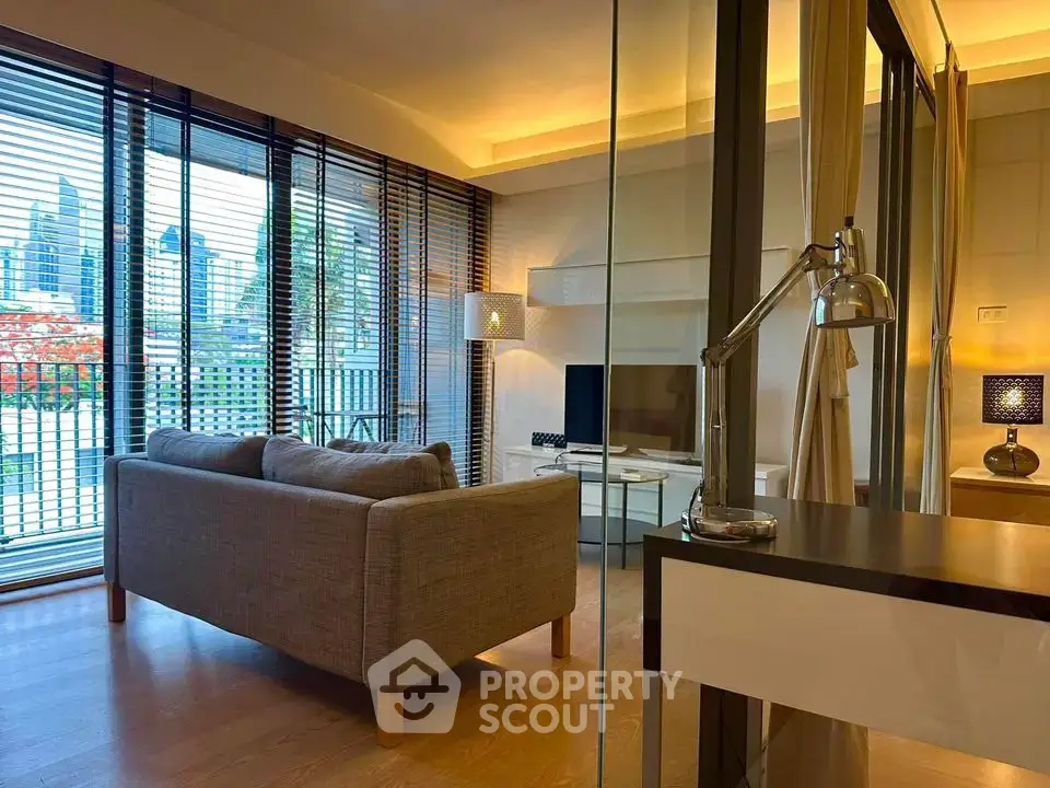 Modern living room with city view, featuring sleek furniture and floor-to-ceiling windows.