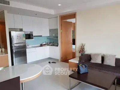 Modern open-layout kitchen and living room with sleek design and cozy ambiance.