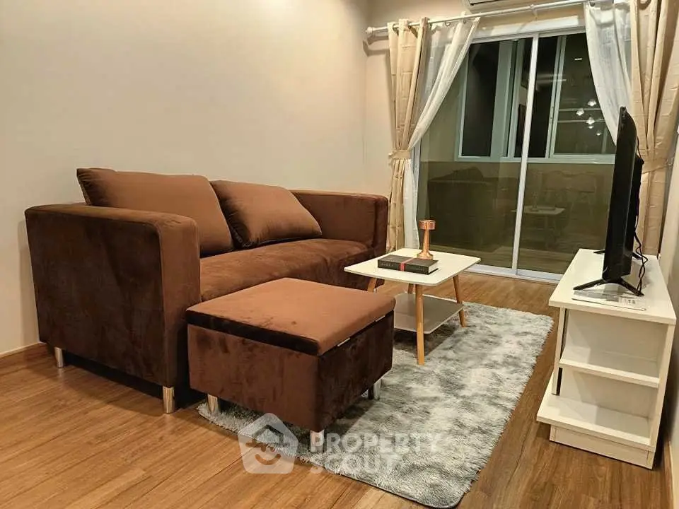 Cozy living room with brown sofa, modern decor, and sliding glass doors leading to balcony.