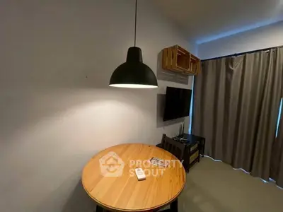 Cozy living room with modern lighting and wooden table, perfect for relaxation.