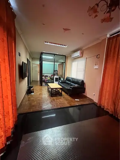 Spacious living room with modern decor and large windows, perfect for relaxation and entertainment.