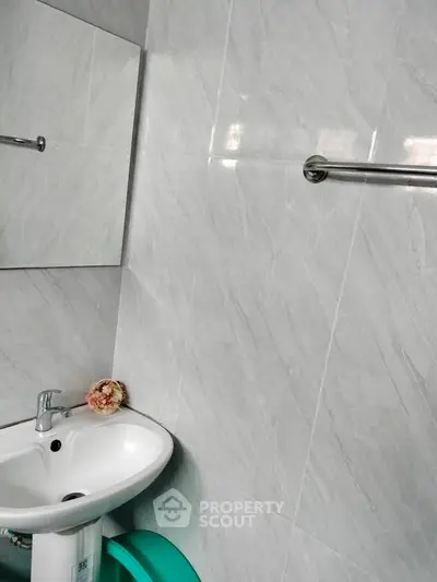 Modern bathroom with sleek white tiles and compact sink