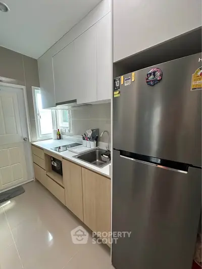 Modern kitchen with sleek cabinetry and stainless steel fridge