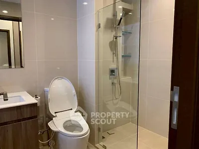Modern bathroom with sleek shower and smart toilet in contemporary design.