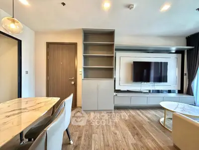 Modern living room with stylish furniture and wall-mounted TV in a contemporary apartment.