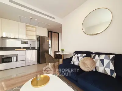 Modern living room with stylish decor and open kitchen layout.
