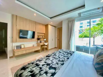 Luxurious bedroom with modern decor and large window overlooking greenery, perfect for relaxation.