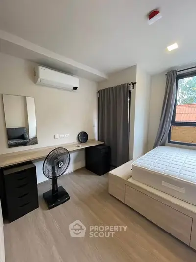 Modern bedroom with air conditioning and natural light, featuring a sleek desk and comfortable bed.
